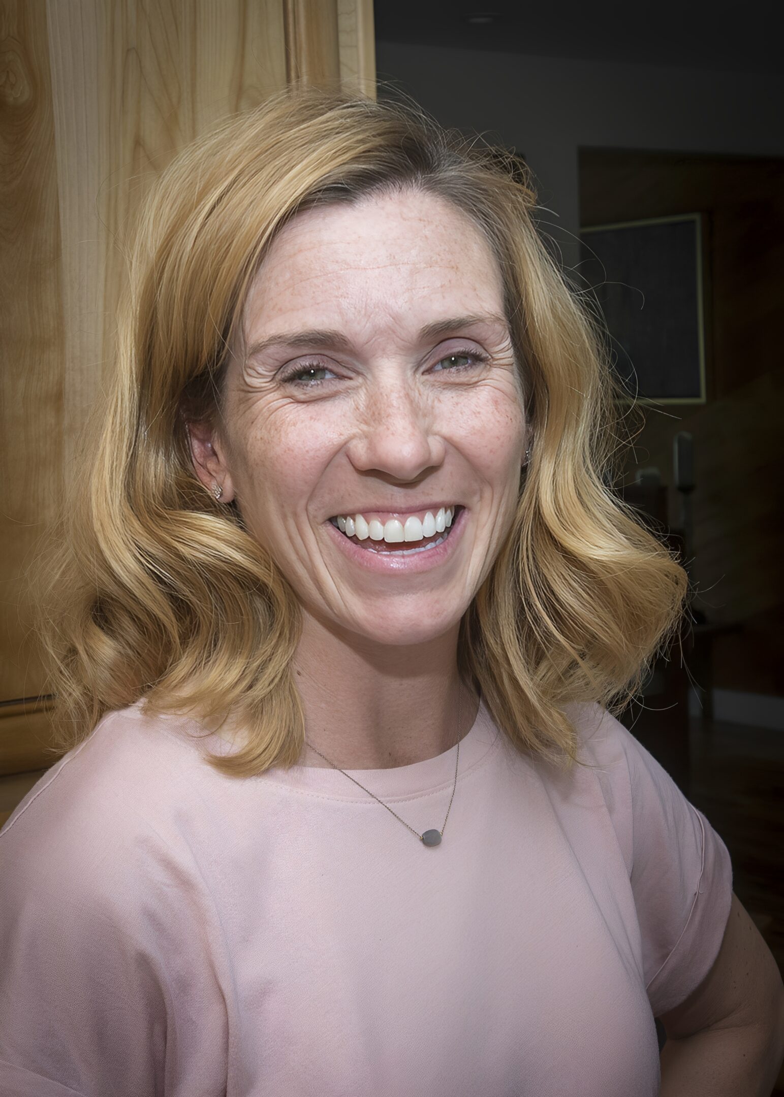 Smiling woman with wavy blonde hair.