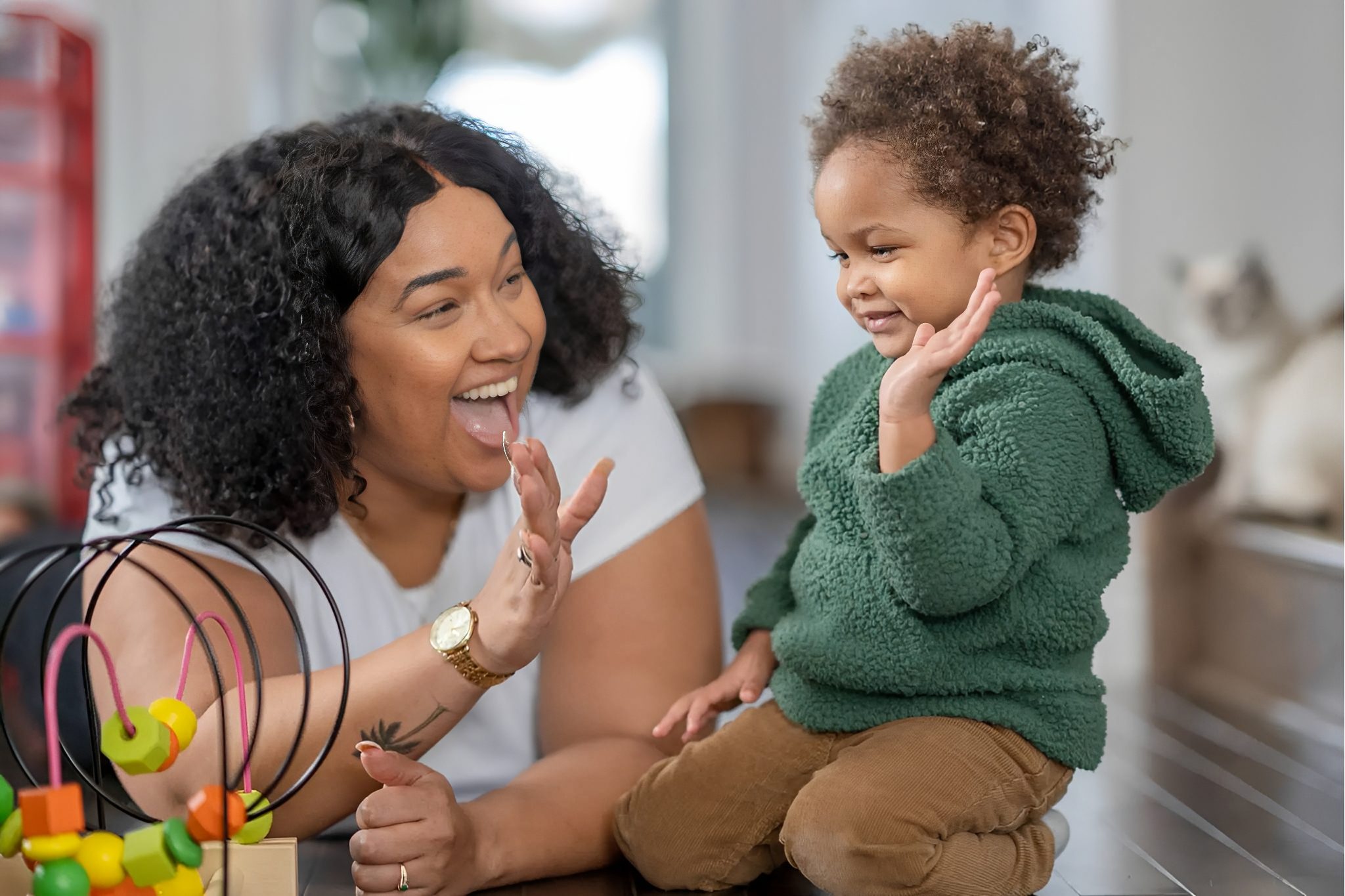 Woman and child high-fiving while playing together.