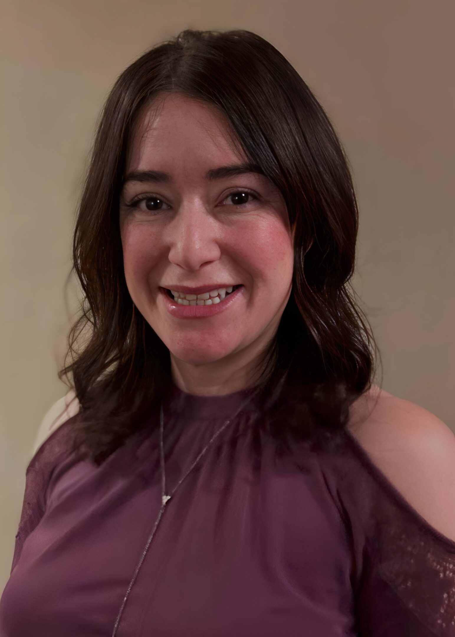 Smiling woman in purple blouse, indoors.